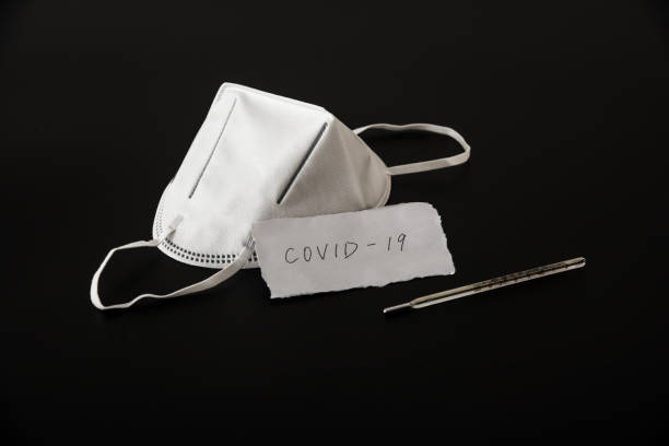 istock Disposable medical mask in black background 1212775143