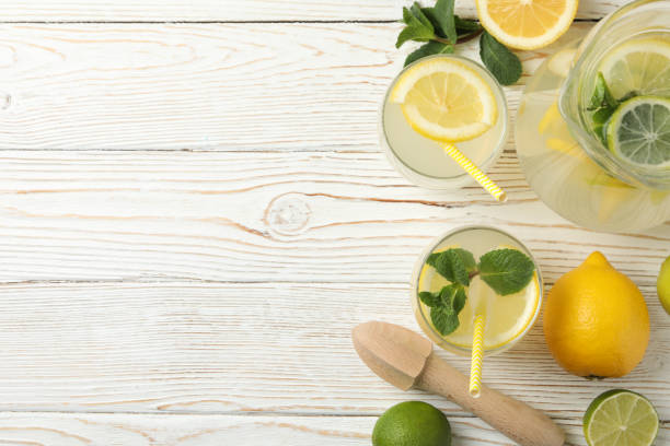 istock Fresh lemonade in different glasses on wooden background, top view 1212775400