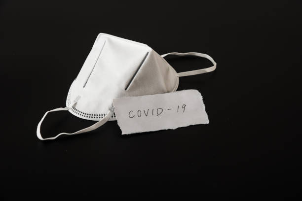 istock Disposable medical mask in black background 1212775578