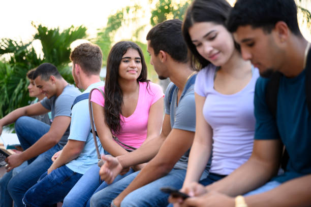 istock Teenagers sitting on campus wall and talking before school 1212776096