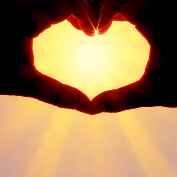 istock Hands forming a heart shape over the sun 1212776217