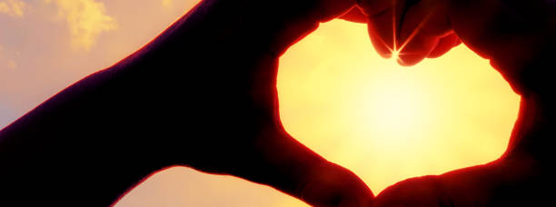 istock Hands forming a heart shape over the sun 1212776247