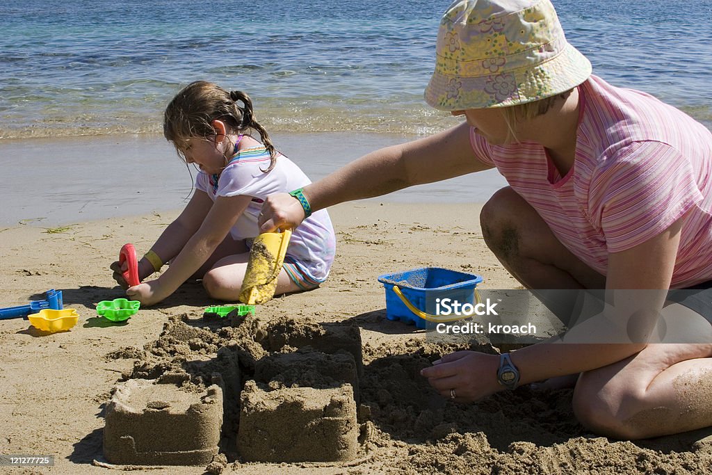 Mother and daughter building a castle  Adult Stock Photo