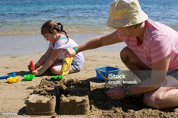 Mother And Daughter Building A Castle Stock Photo - Download Image Now - Adult, Beach, Building - Activity