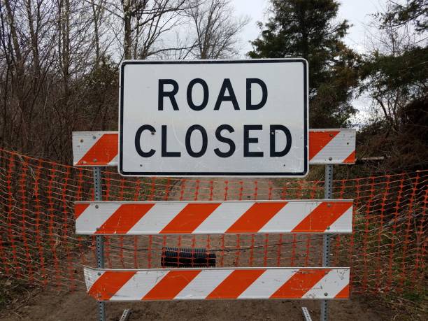 istock white road closed sign and striped barricade with trail or path 1212778150