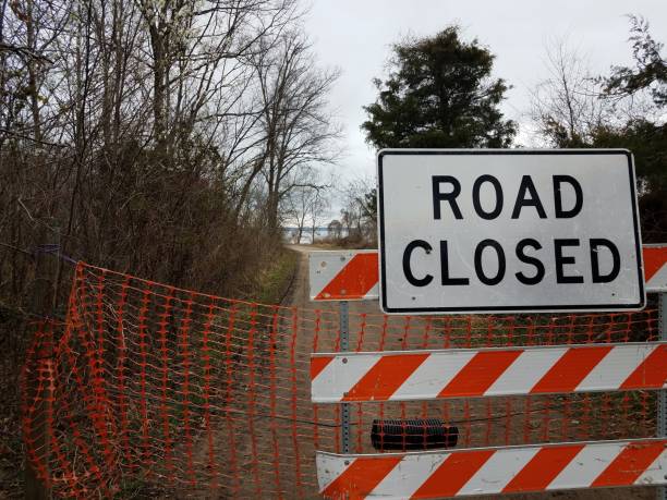 istock white road closed sign and striped barricade with trail or path 1212778219