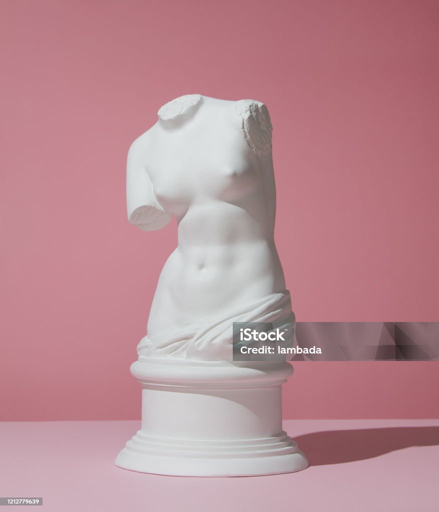 Plaster torso of Venus on pink background Plaster model of female torso (mass produced replica of Venus de Milo) on pink background Statue Stock Photo