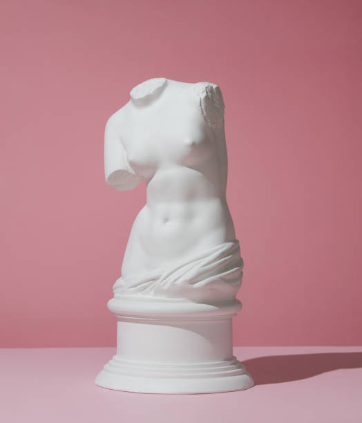 Plaster torso of Venus on pink background stock photo