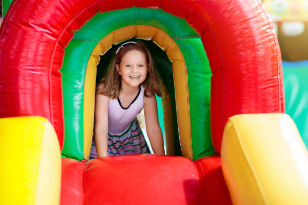 istock Child jumping on playground trampoline. Kids jump. 1212779718