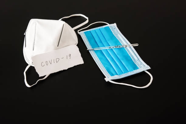 istock Disposable medical mask in black background 1212779964