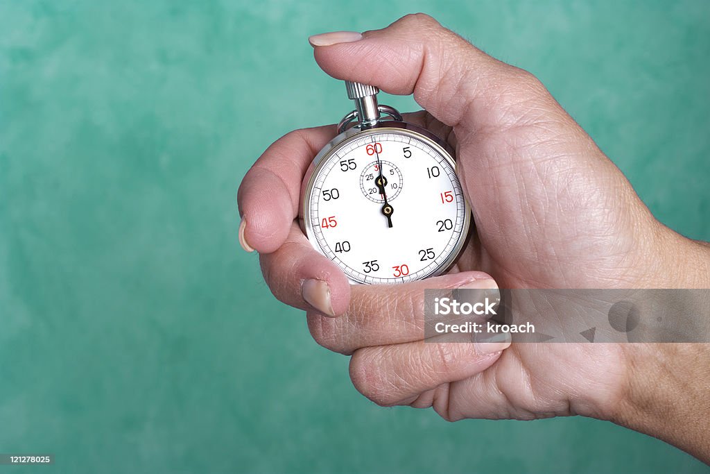 Hand holding stopwatch against green background Stopwatch in hand on green background with copy space Accuracy Stock Photo