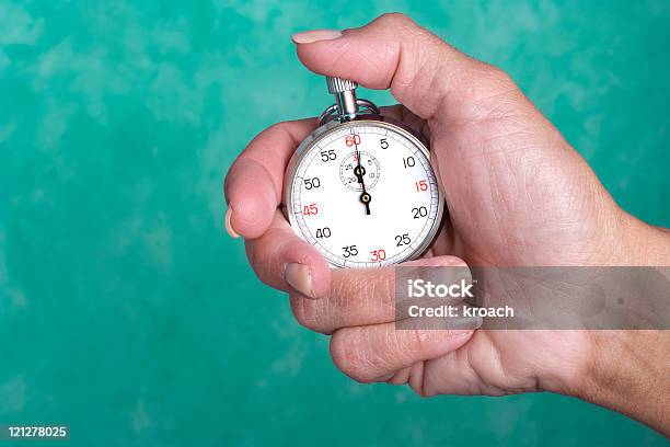 Hand Holding Stopwatch Against Green Background Stock Photo - Download Image Now - Accuracy, Clock Face, Coach
