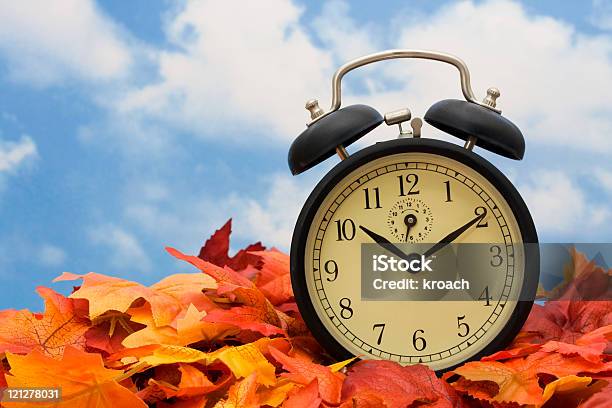 Alarm Clock Sitting On Fall Leaves Indicating Time Change Stock Photo - Download Image Now