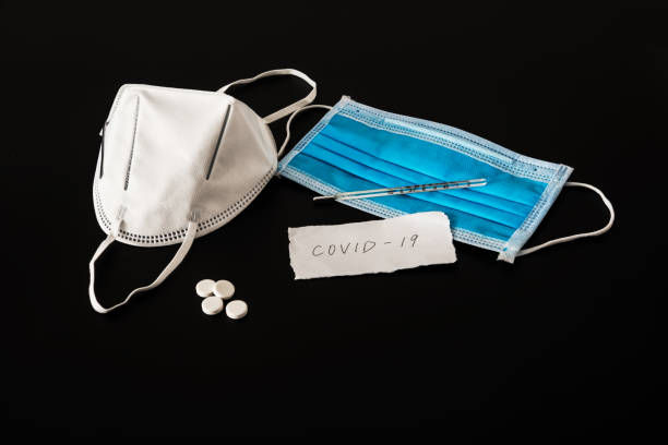 istock Disposable medical mask in black background 1212781436