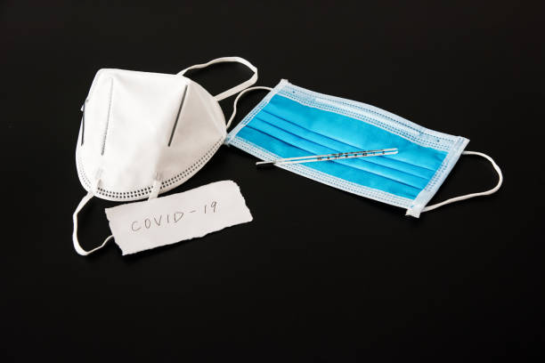 istock Disposable medical mask in black background 1212781464