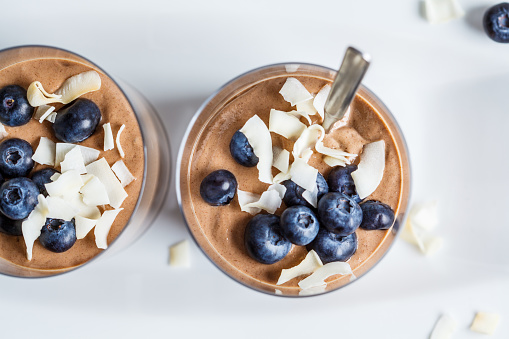 Chocolate mousse smoothie with berries and coconut in a glass for breakfast.