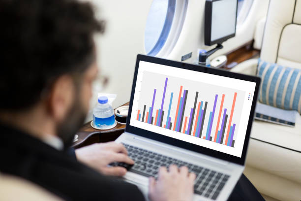 istock Businessman working on laptop in private jet airplane 1212783560