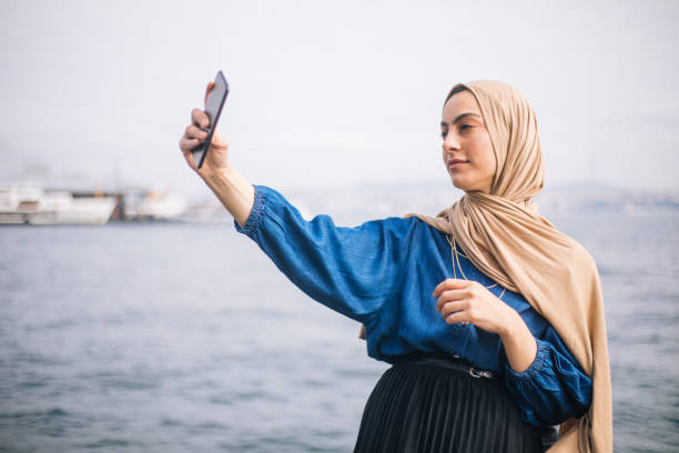 istock Happy young woman taking selfie 1212784995