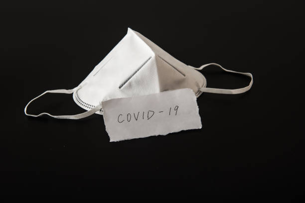 istock Disposable medical mask in black background 1212785056