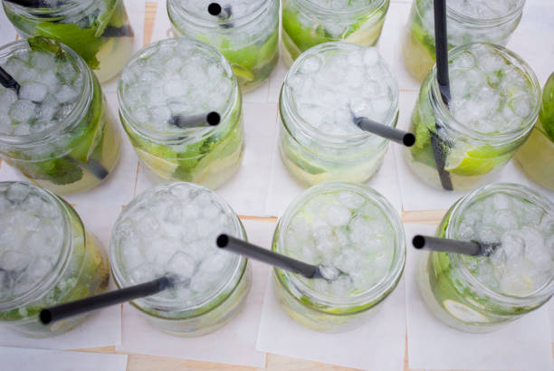 Full fresh made mojito glasses with green leaves, sugar and lime. Overhead view