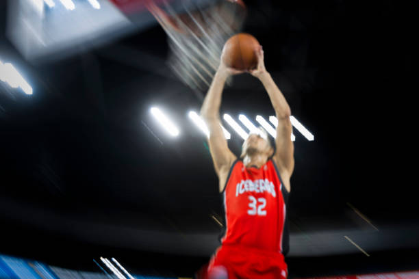 istock Basketball player slam dunking ball 1212788852