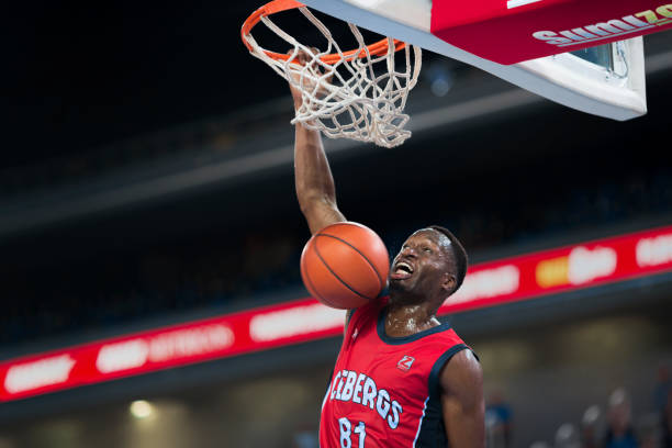 istock Basketball player slam dunking ball 1212788938