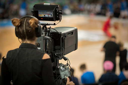 Mujer camarógrafo disparando juego de baloncesto photo
