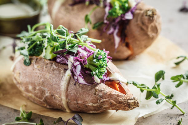 istock Baked sweet potatoes stuffed with quinoa, broccoli and cabbage, dark background. 1212792266