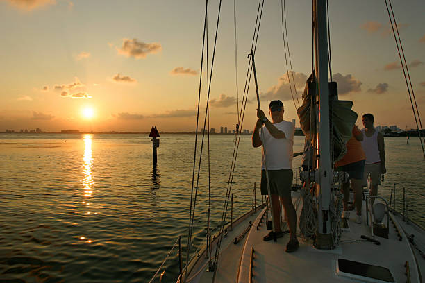 Gruppo in barca a vela al tramonto - foto stock