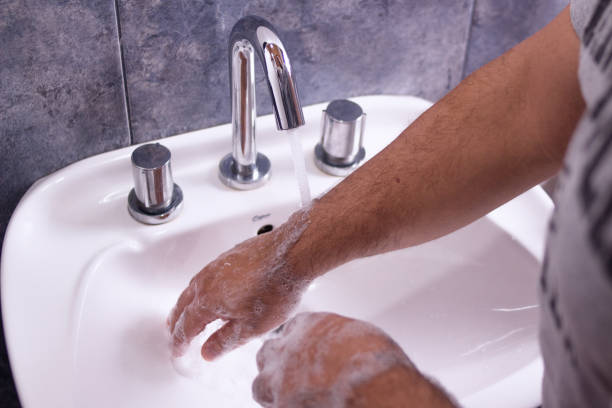 istock Man washing his hands with neutral soap and water - rinse 1212796814