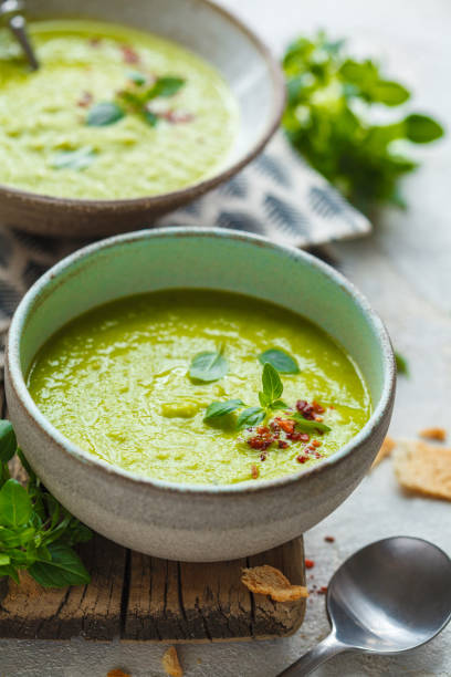 istock Green peas soup with basil in vintage bowls, vertical shot. 1212800523