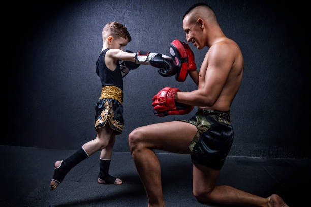 Kickboxing coach is training the boy. The concept of family, sports, mma, muay thai. stock photo
