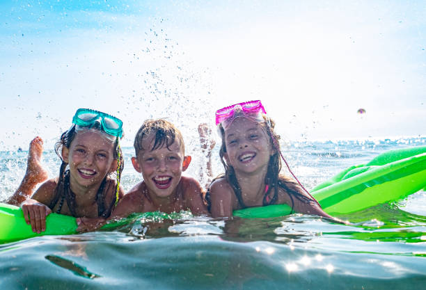 istock Children splashing in the sea 1212801762