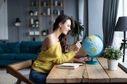 Charming woman looking on globe. Travel concept.