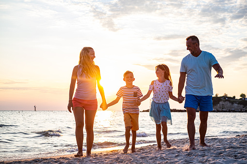 Happy family walking together at the beach