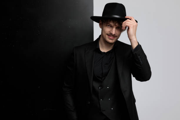 istock Positive fashion model fixing his hat and greeting 1212803382