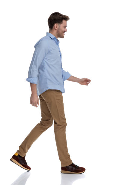 istock Side view of cheerful casual man smiling while walking 1212804419