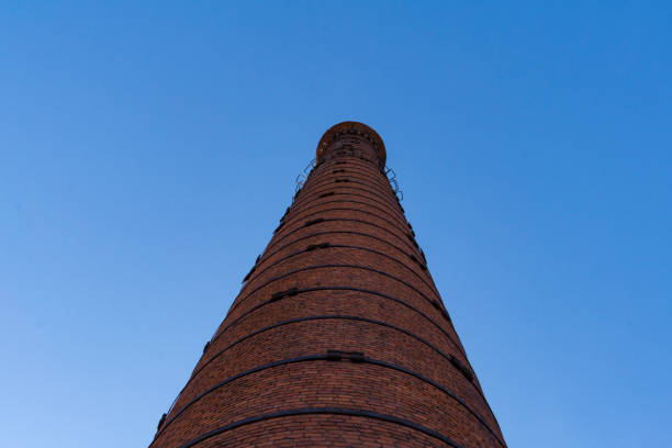 istock A large red brick pipe against a blue sky. View from below. Industrial background. 1212806287