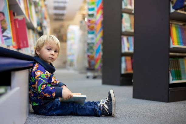istock Adorable little boy, sitting in a book store 1212808577