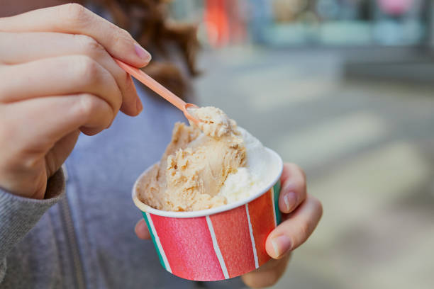 cup with ice cream in girl´s hands with a spoon stock photo