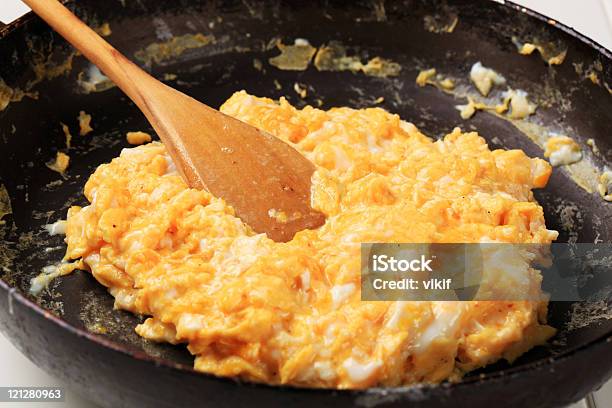 Closeup Of Cooking Scrambled Eggs In A Pan Stock Photo - Download Image Now - Scrambled Eggs, Wooden Spoon, Black Color