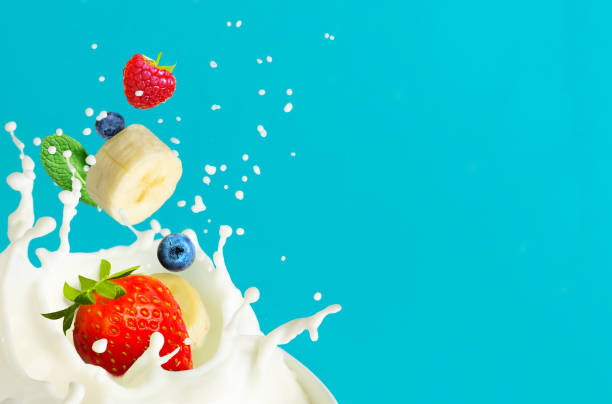 istock Cream splash with falling fruits and berries on aqua blue background. Copy space 1212810308