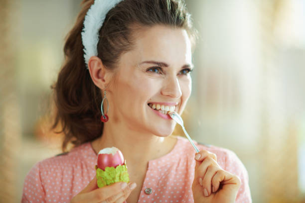 istock woman eating egg with spoon at modern home in sunny spring day 1212810633