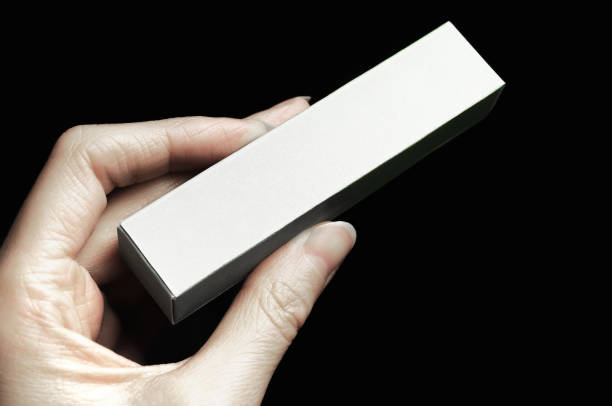istock Female hand holding blank box or cosmetic package 1212812572