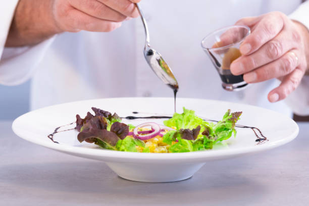 istock Male chef decorating a salad dish with vinegar 1212815181