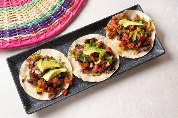 istock Mexican pork chorizo tacos with avocado and beans on white background 1212815393