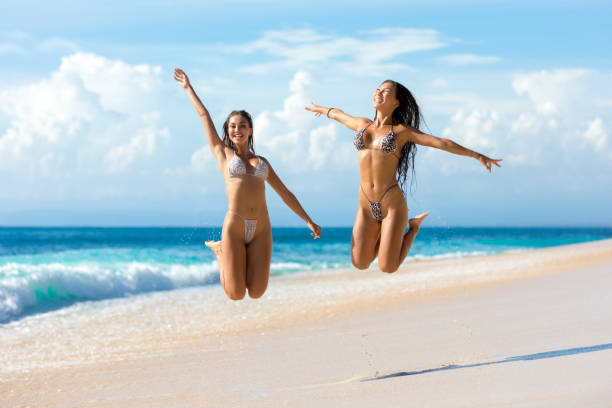 istock Two young women enjoying the beach 1212817523