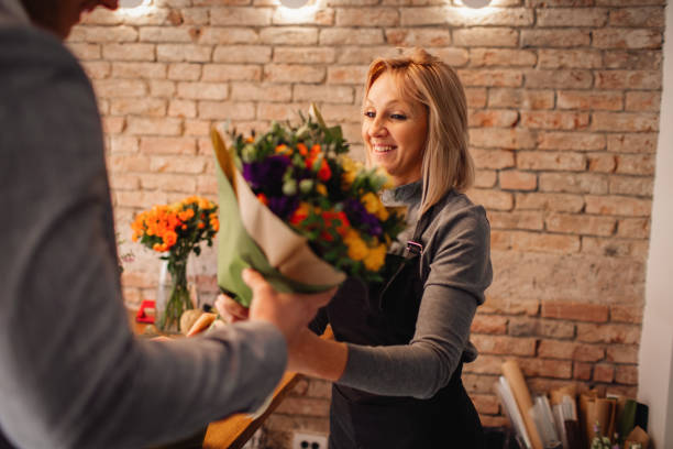 istock Florist Giving Beautiful Bouquet To Customer 1212819733
