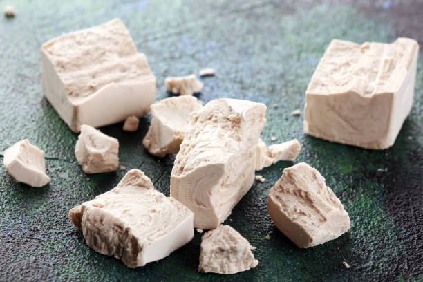 istock Dry yeast crumbled and yeast block for baking on background 1212822491