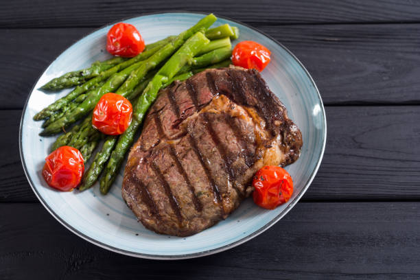 istock Grilled beef steak ribeye with cherry tomatoes and asparagus 1212823885